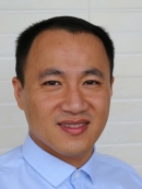 headshot of Asian male with short dark hair wearing a blue buttoned shirt